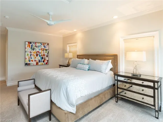 Carpeted bedroom featuring ornamental molding and ceiling fan