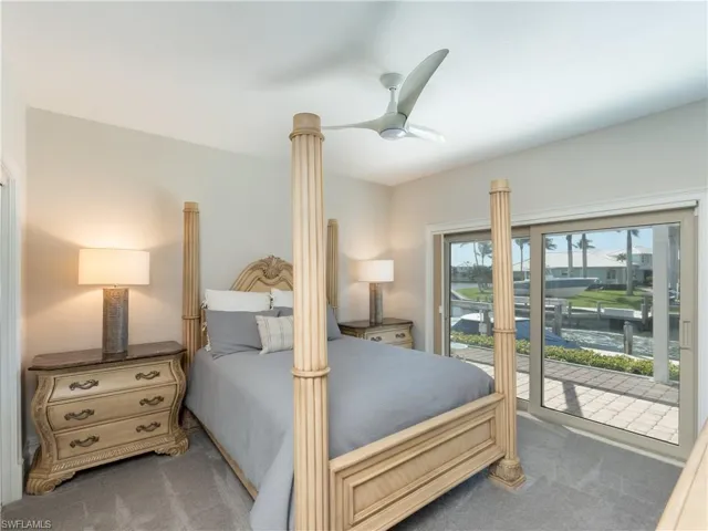 Carpeted bedroom featuring ceiling fan and access to exterior