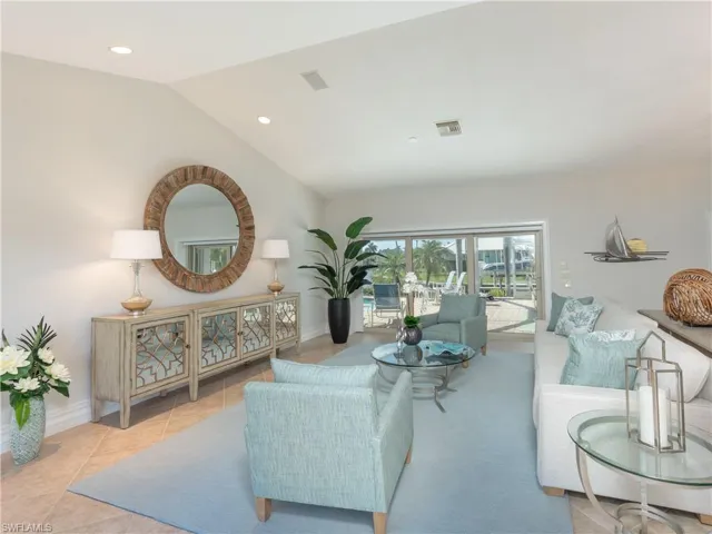 Living room featuring light tile patterned floors and vaulted ceiling