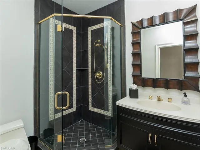 Bathroom with an enclosed shower, vanity, and toilet