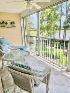 Sunroom featuring ceiling fan and a balcony