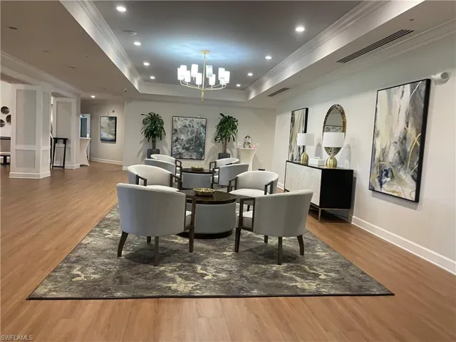 Dining room featuring light wood finished floors, a tray ceiling, ornamental molding, recessed lighting, and a chandelier