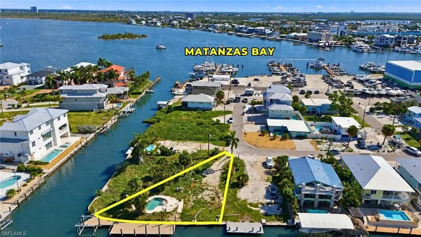 Waterfront lot with canal access featuring a private dock and a small pool - Virtually Edited Image