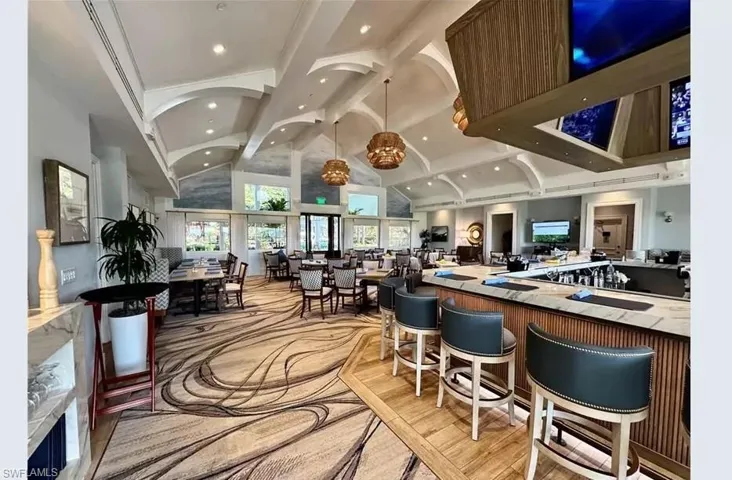 Bar with beamed ceiling, high vaulted ceiling, and recessed lighting
