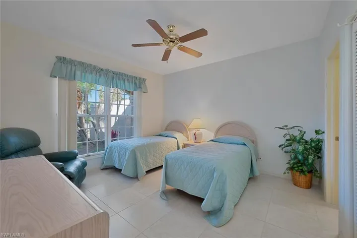 Tiled Guest bedroom with ceiling fan and bathroom