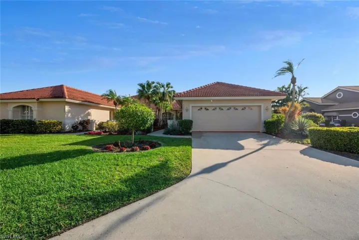 View of front of house with a garage and a front lawn