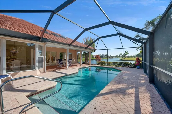 View of swimming pool featuring a lanai, a patio, and a water and golf course view