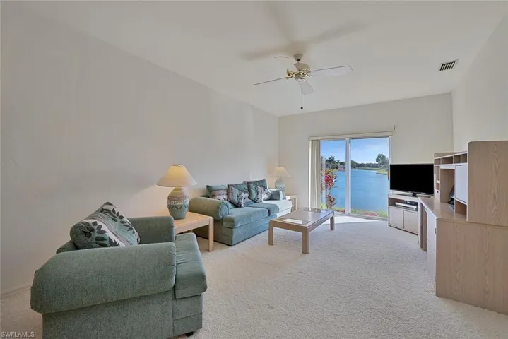 3rd Bedroom featuring ceiling fan, light carpet and gorgeous water and golf course view. Currently used as den, with 3rd bathroom entrance.