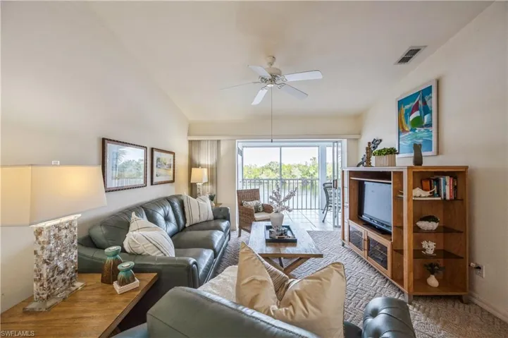 Living area with ceiling fan and vaulted ceiling