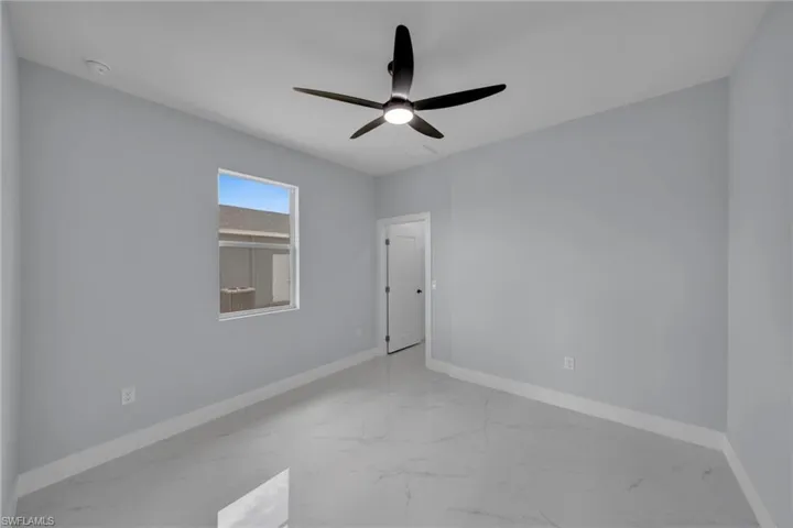 Empty room with light marble finish flooring and ceiling fan