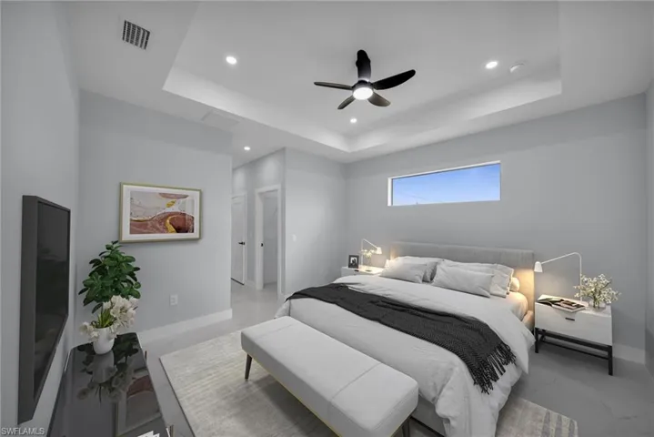 Bedroom featuring a raised ceiling, recessed lighting, and a ceiling fan