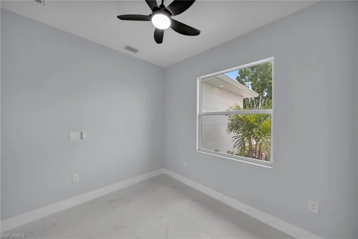 Spare room with light marble finish flooring and ceiling fan