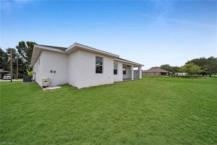 Back of property with a yard, stucco siding, and a patio