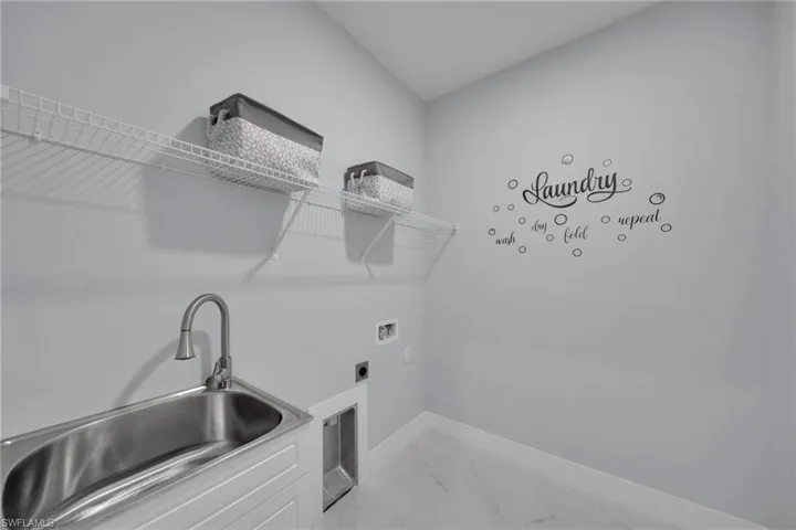 Laundry area featuring light marble finish floors, hookup for a washing machine, and electric dryer hookup