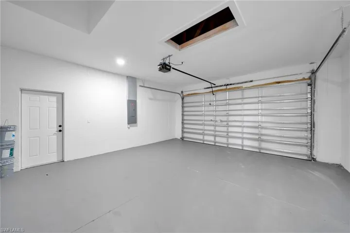 Garage featuring electric panel and a garage door opener