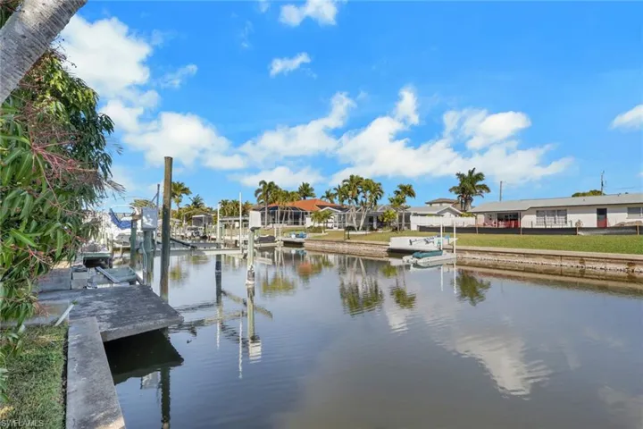 Dock with a water view, boat lift, and a residential view