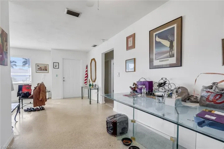 Hallway with dark aggregate flooring and baseboards