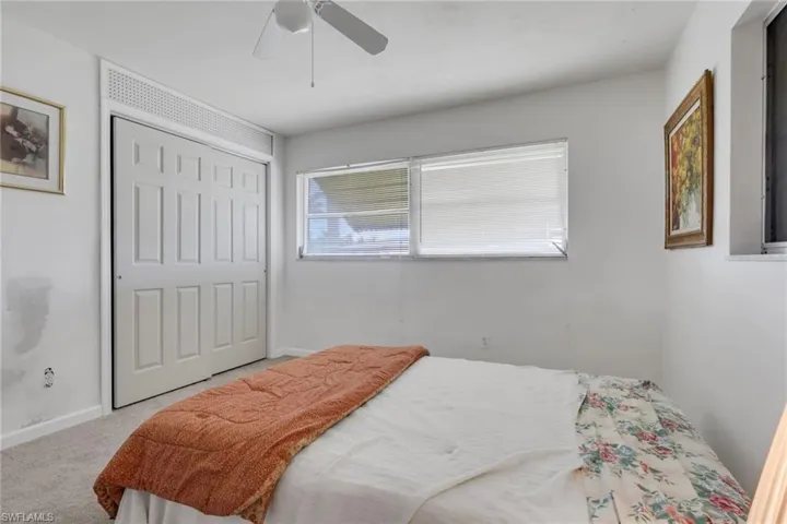 Carpeted bedroom featuring a closet and ceiling fan