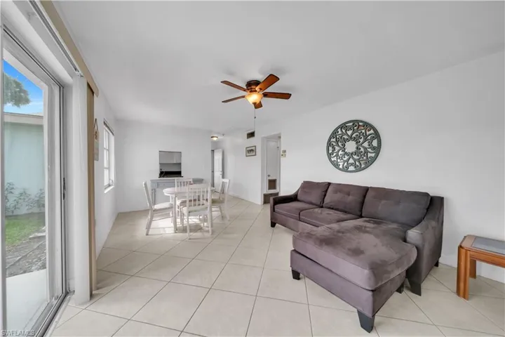 Living room with a ceiling fan and light tile patterned floors