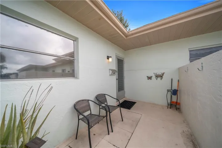 Doorway to property featuring stucco siding and a patio area