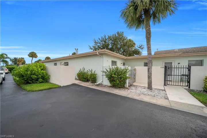 View of side of home with a gate, stucco siding, and a fenced front yard