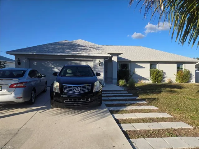 Ranch-style home with a shingled roof, a front lawn, stucco siding, concrete driveway, and a garage
