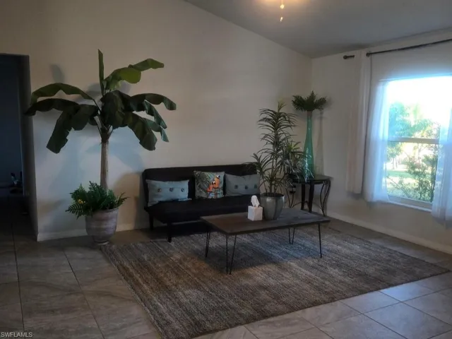 Living room with baseboards and tile patterned flooring