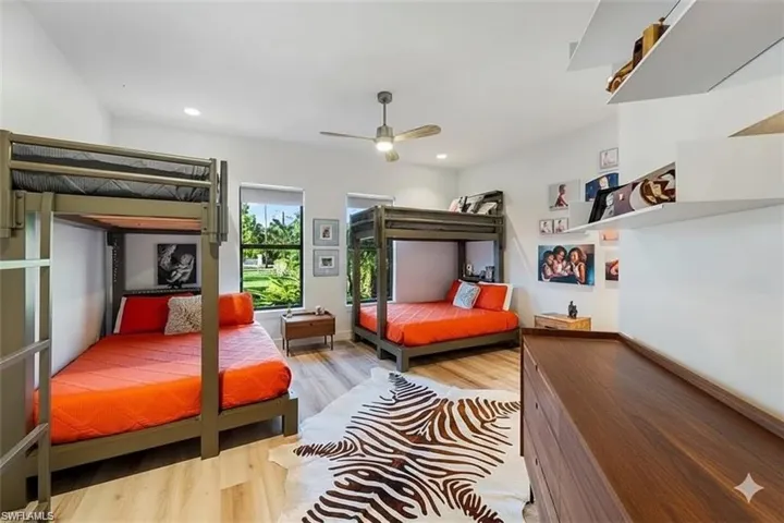 Bedroom with light wood finished floors, ceiling fan, and recessed lighting