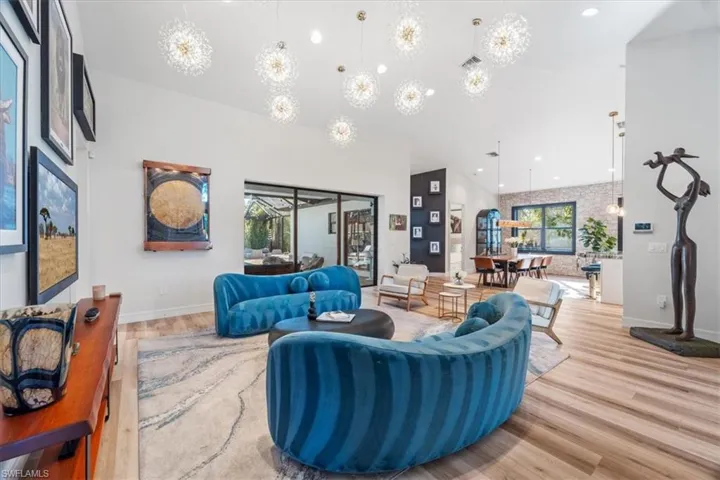 Living room featuring recessed lighting, a high ceiling, baseboards, and wood finished floors