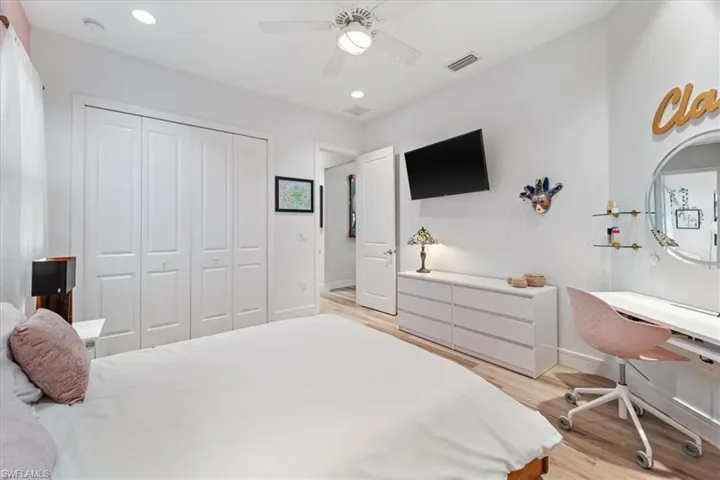 Bedroom featuring visible vents, light wood-style flooring, recessed lighting, and a closet
