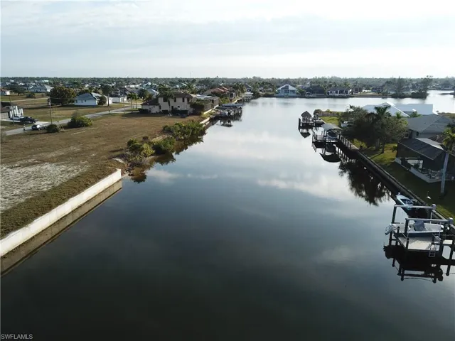 Water view featuring a boat dock and nearby suburban area