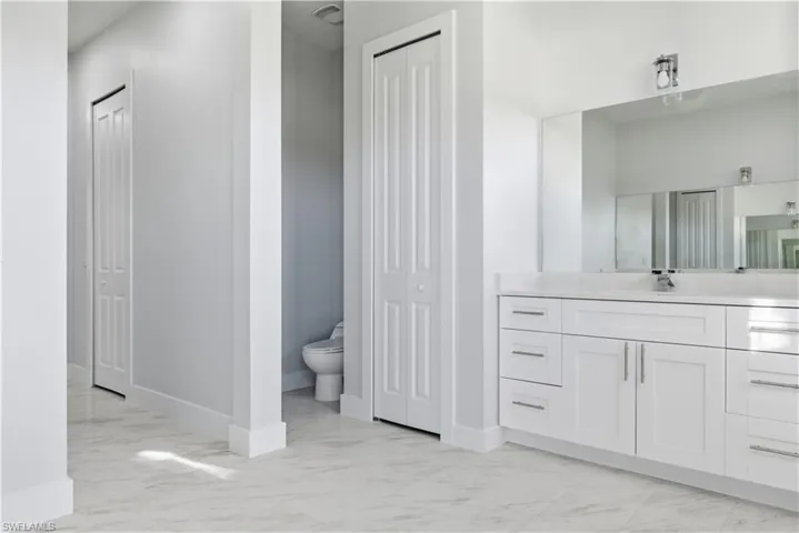 Full bathroom with a closet, light marble finish flooring, and vanity