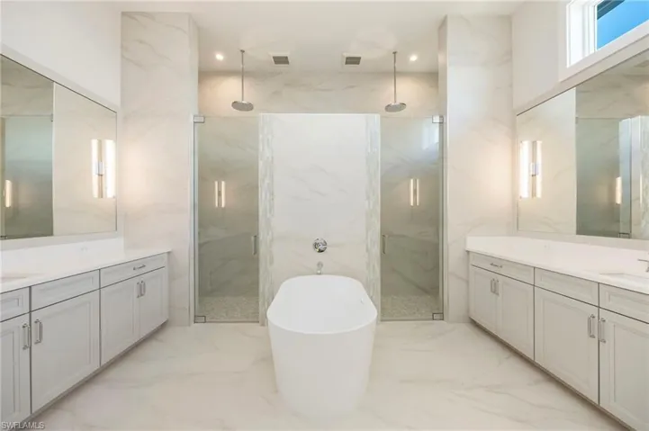 The primary bathroom features dual-entry shower, dual vanities, private water closet, and soaking tub. So much light!
