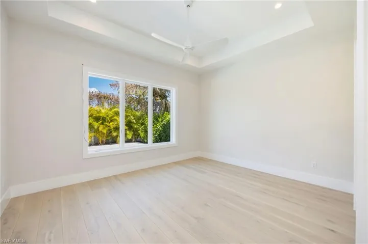 Bedroom 3 enjoys so much light and a view of the pool deck with landscaping for privacy.