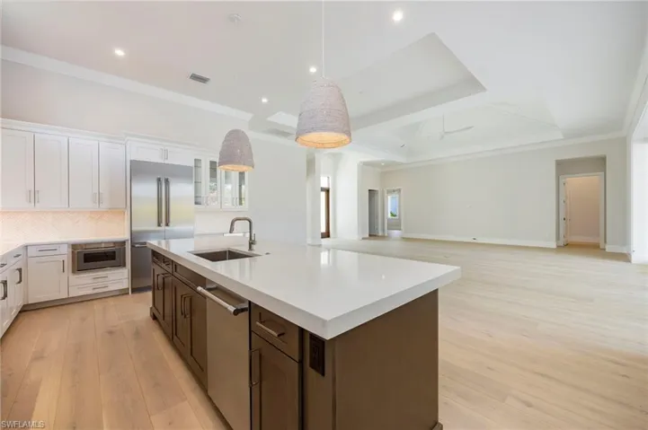 White oak flooring continues through the home into the kitchen. The kitchen featurs white perimater cabinets, wood grain island, Pompeii quartz countertops, marble backsplash, Thermador appliances, pantry, and so much more!