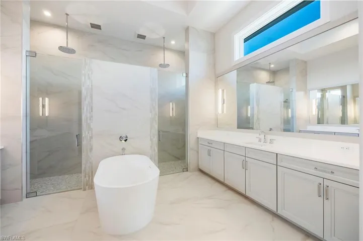 The primary bathroom features dual-entry shower, dual vanities, private water closet, and soaking tub. So much light!