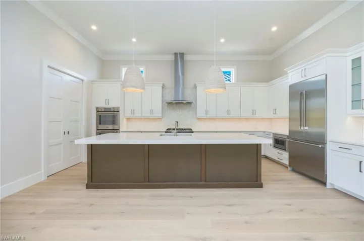 White oak flooring continues through the home into the kitchen. The kitchen featurs white perimater cabinets, wood grain island, Pompeii quartz countertops, marble backsplash, Thermador appliances, pantry, and so much more!