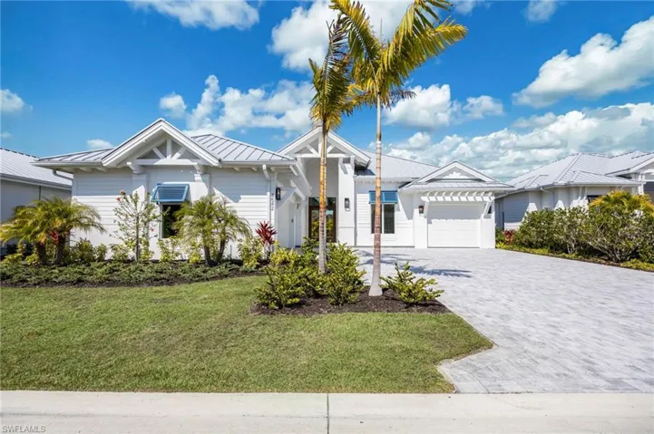 4542 Seagrove Landing Way features a split 3-car garage plan (2/1), crisp white paint, decorative blue shutters, and standing seam metal roof.