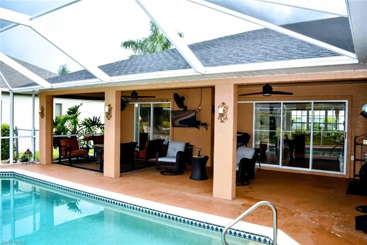 Outdoor pool featuring screened in patio area