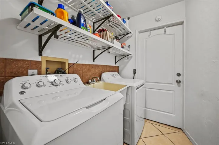 Laundry room featuring separate washer and dryer and light tile patterned floors