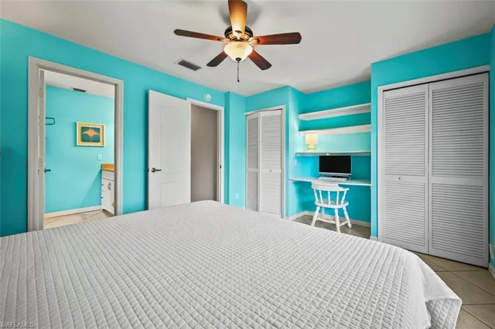 Bedroom featuring two closets, tile patterned flooring, and ceiling fan