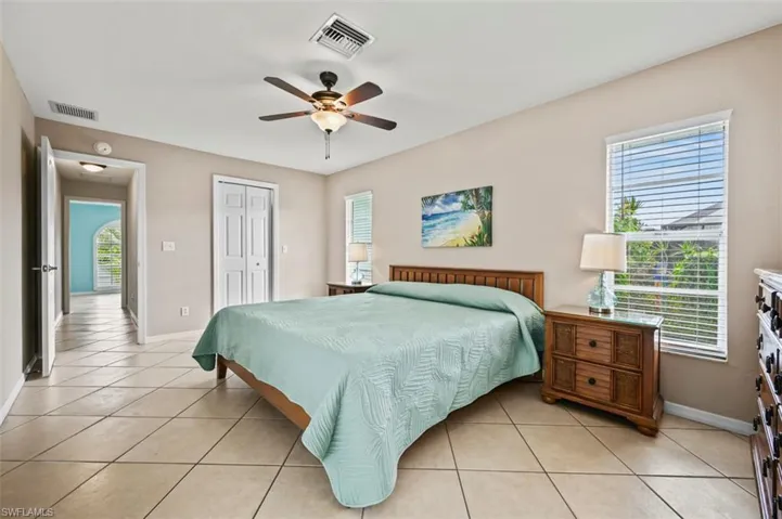 Bedroom with light tile patterned flooring, a closet, and a ceiling fan