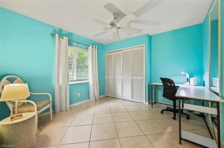 Tiled office featuring a ceiling fan and baseboards