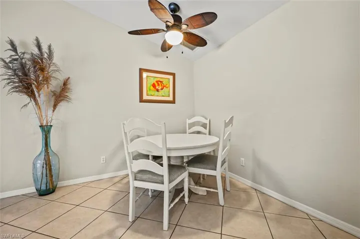 Dining room featuring ceiling fan, lofted ceiling, and light tile patterned floors