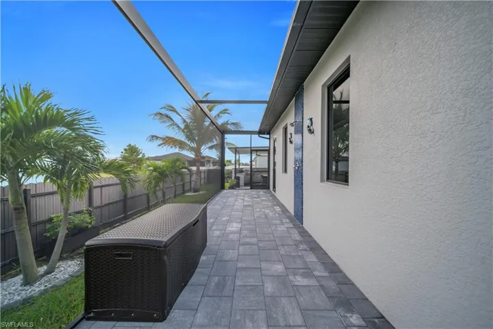 Screened-in patio featuring paver flooring, stucco exterior, and decorative tile accents