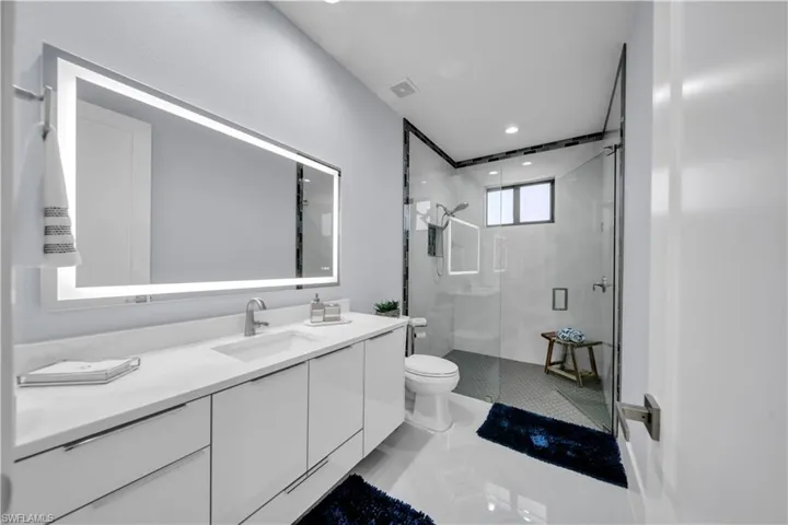 Modern bathroom featuring a single vanity with a white countertop and integrated rectangular sink