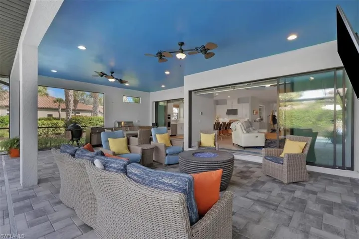 View of patio with an outdoor living space with a fire pit, ceiling fan, and a grill