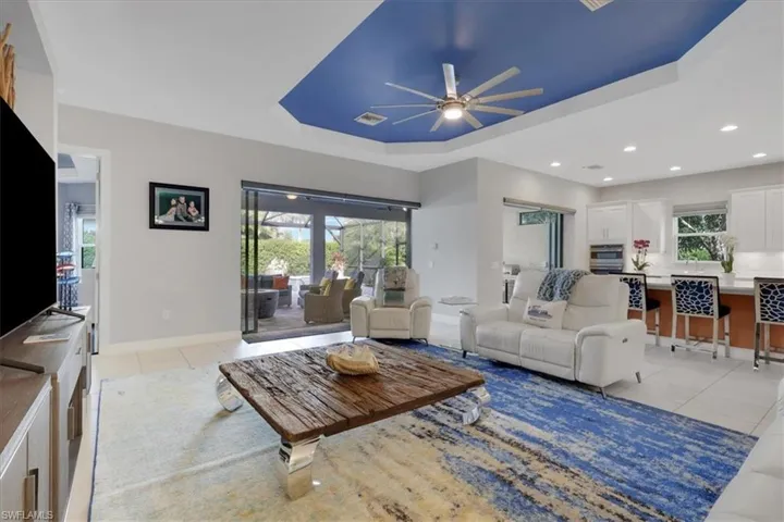 Living room with light tile patterned floors, ceiling fan, and plenty of natural light