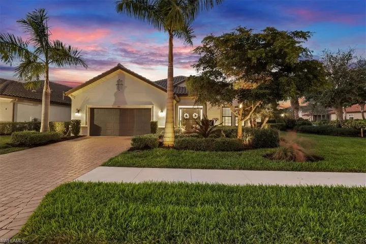 Mediterranean / spanish-style home with a lawn, stucco siding, decorative driveway, a garage, and a tiled roof