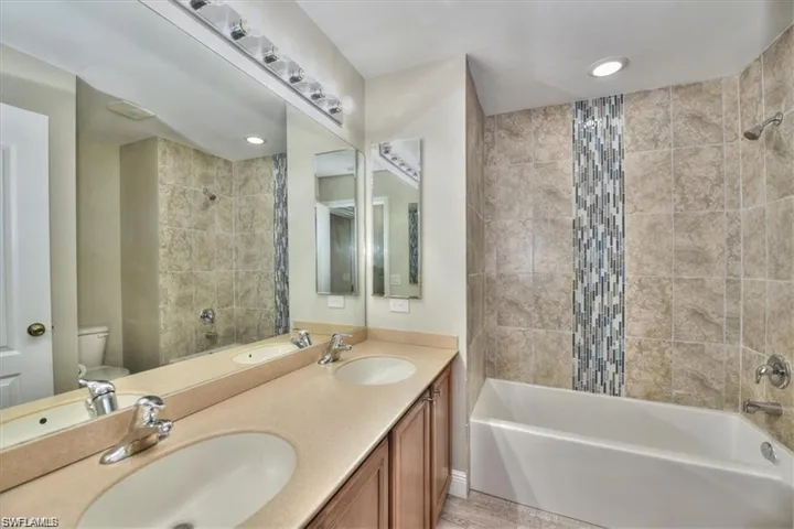 Full bathroom with vanity, toilet, and tiled shower / bath